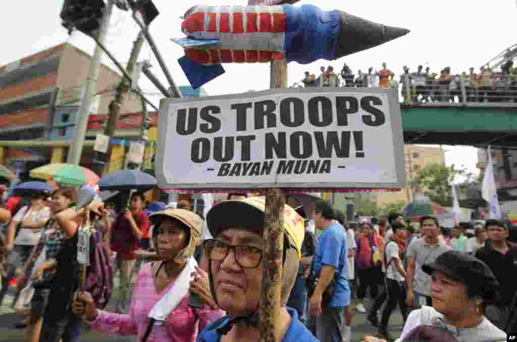 A Filipino activist holds a slogan near the Malacanang presidential palace in Manila, Philippines, Monday April 28, 2014 during a rally to oppose the Enhanced Defense Cooperation Agreement between the Philippines and U.S. The U.S. military will have great