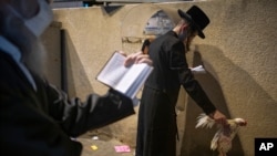 An ultra-Orthodox Jewish man holds a chicken as part of the Kaparot ritual, Sept. 27, 2020. The solemn Jewish holiday of Yom Kippur sees annually Israeli life grind to a halt, arrived on Sunday in a nation already under a sweeping coronavirus lockdown.