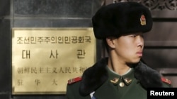 FILE - A paramilitary soldier stands guard at the main gate of North Korea's embassy in Beijing Jan. 6, 2016. 