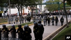 ARCHIVO - La policía formada en posición defensiva cerca del aeropuerto ante el avance de manifestantes contra el gobierno en Cusco, Perú, el jueves 2 de febrero de 2023.