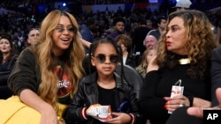 Beyonce (kiri) bersama putrinya, Blue Ivy Carter (tengah) dan ibunya, Tina, menyaksikan laga bola basket NBA All-Star, di Los Angeles, 18 Februari 2018. (AP Photo/Chris Pizzello)