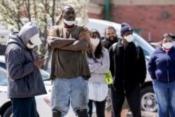 FILE - People line up for a COVID-19 test in a parking lot Monday May 11, 2020, in Milwaukee. This was one of two sites in the city to open Monday and offer free testing. (AP Photo/Morry Gash)