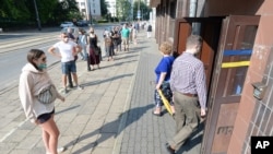Personas en Varsovia, Polonia, observan las regulaciones contra el COVID-19 mientras votan en la elección presidencial, que fue aplazada en mayo por la pandemia. Junio 28 de 2019.