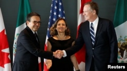 Mexico's Economy Minister Ildefonso Guajardo, left, shakes hands with U.S. Trade Representative Robert Lighthizer before the start of a trilateral meeting with Canada's Foreign Minister Chrystia Freeland during the third round of NAFTA talks in Ottawa, Ontario, Sept. 27, 2017.