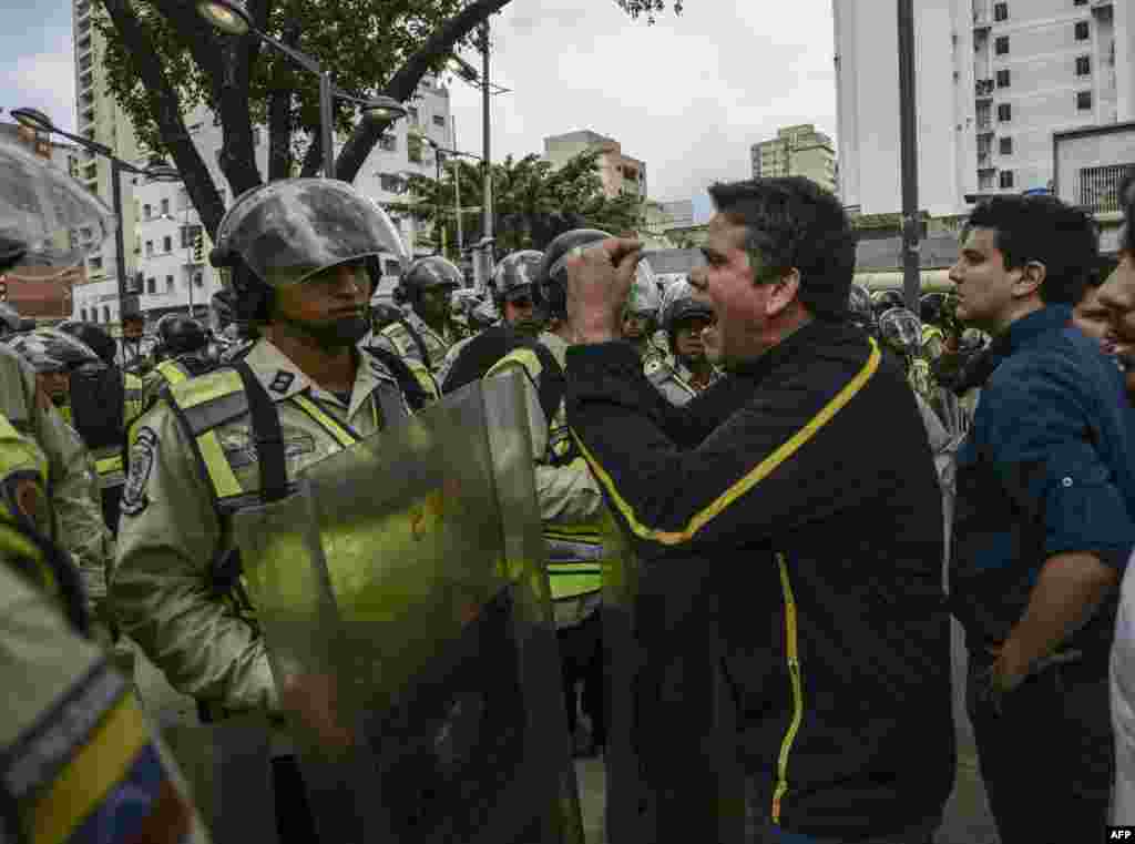 Venezuelan opposition deputy Rafael Guzman (C), confronts National Guard personnel during a protest in front of the National Attorney's General office building in Caracas, March 31, 2017.