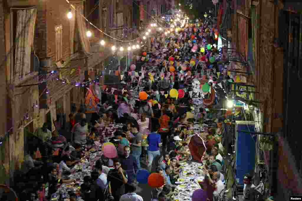 ប្រជាជននៃ តំបន់ Ezbet Hamada ស្រុក Cairo's Mataria ប្រទេសអេហ្ស៊ីបប្រមូលផ្តុំគ្នាបរិភោគ Iftar ដែលអាហារបញ្ចប់ការតមរបស់ពួកគេនៅពេលព្រះអាទិត្យលិចអំឡុងខែរ៉ាម៉ាដង់កាលពីថ្ងៃទី២០ ខែឧសភា ឆ្នាំ២០១៩។ 