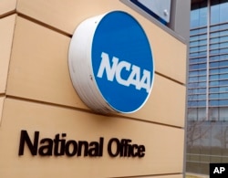 FILE - Signage is on the headquarters of the NCAA in Indianapolis, March 12, 2020. (AP Photo/Michael Conroy, File)
