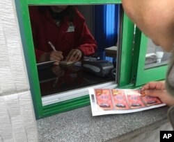 FILE - A customer pays for gasoline at a station in Pyongyang, North Korea, Feb. 22, 2016. Higher prices were a problem in early 2016, but recently an apparent gas shortage is causing the pain at the pump.