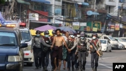 police march with a resident arrested during a crackdown on protesters
