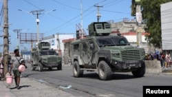 Vehículos blindados de la misión de mantenimiento de la paz de Kenia patrullan mientras los residentes huyen de su vecindario debido a la violencia de las pandillas, en Puerto Príncipe, Haití, el 25 de febrero de 2025.