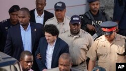 ARCHIVO - El fundador de FTX, Sam Bankman-Fried, centro izquierda, es acompañado fuera del Tribunal de Primera Instancia luego de una audiencia en Nassau, Bahamas, el 19 de diciembre de 2022. (Foto AP/Rebecca Blackwell, archivo)