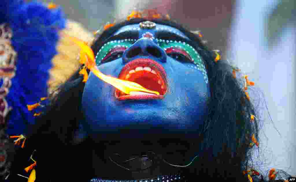 Seorang seniman India berpakaian seperti Dewi Hindu Kali memeriahkan perayaan festival Ram Navami, memperingati hari kelahiran Dewa Rama di kota Allahabad.