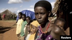 FILE - A women and her children stand next to their house on the outskirts of Moyale, Ethiopia, a nation where not many books are written in local languages, and few Ethiopians read for pleasure.