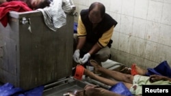 Petugas forensik memberi tanda pada jenazah warga Burma di sebuah RS di Medan yang tewas dalam perkelahian di pusat penahanan (5/4).