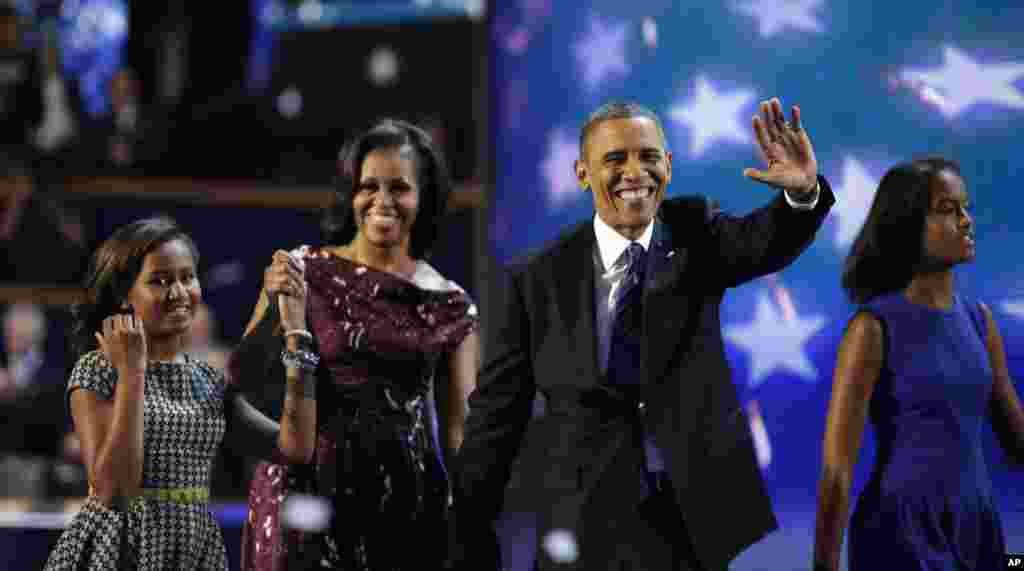 President Barack Obama and First lady Michelle Obama joined by their children Sasha, left, and Malia walks across the stage after President Obama's speech to the Democratic National Convention.