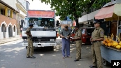 Policías de Sri Lanka realizan un chequeo de seguridad a un camión en una calle de Colombo, el jueves 25 de abril de 2019.