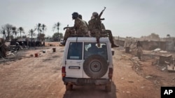 Pasukan pemerintah Sudan Selatan berkendara melewati kota yang dibumihanguskan di negara bagian Unity, Sudan Selatan, 12 Januari 2014. 
