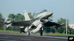A Taiwan Air Force F-16 fighter jet lands on a closed section of highway during the annual Han Kuang military exercises in Chiayi, central Taiwan, Sept. 16, 2014. 