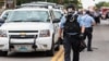 FILE - Police wear gas masks as they attempt to disperse a crowd that gathered after a shooting incident in St. Louis, Missouri August 19, 2015. 