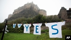 A "Yes" campaign sign for the Scottish independence referendum stands with Edinburgh Castle in the background, in Edinburgh, Sept. 18, 2014. 