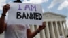 FILE - Mehrad Ansari of Iran holds a sign outside the U.S. Supreme Court after U.S. President Donald Trump's travel ban was upheld in Washington, June 26, 2018. 