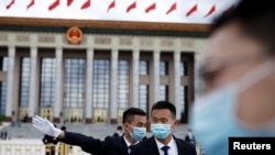 預防病毒傳播和減少感染新冠病例，戴口罩可能比保持社交距離或者禁足在家都更為重要。中國保安在正在舉行中國人大會議的北京人大會堂外站崗。（路透社2020年5月25日資料照）