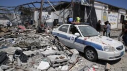 Debris covers the ground and an emergency vehicle after an airstrike at a detention center in Tajoura, east of Tripoli in Libya, Wednesday, July 3, 2019. An airstrike hit the detention center for migrants, killing several, July 3, 2019.