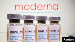 Botol dengan stiker bertuliskan, "COVID-19/vaksin Corona/Injeksi saja" dan jarum suntik medis terlihat di depan logo Moderna yang ditampilkan dalam ilustrasi yang diambil pada tanggal 31 Oktober 2020. (Foto: REUTERS/Dado Ruvic)