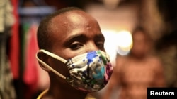 Eugene Amuri, seorang penjual di pasar Kimironko mengenakan "kitenge", masker dari kain untuk melindungi dari penularan virus corona, (COVID-19), di Kigali, Rwanda, 17 Maret 2020. (Foto: Reuters)