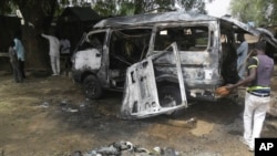 尼日利亚城市波蒂斯库姆发生公交车爆炸后，人们检查这辆汽车
