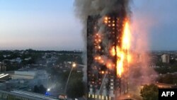 FILE - This handout image received by local resident Natalie Oxford early on June 14, 2017 shows flames and smoke coming from a 27-story block of flats after a fire broke out in west London.