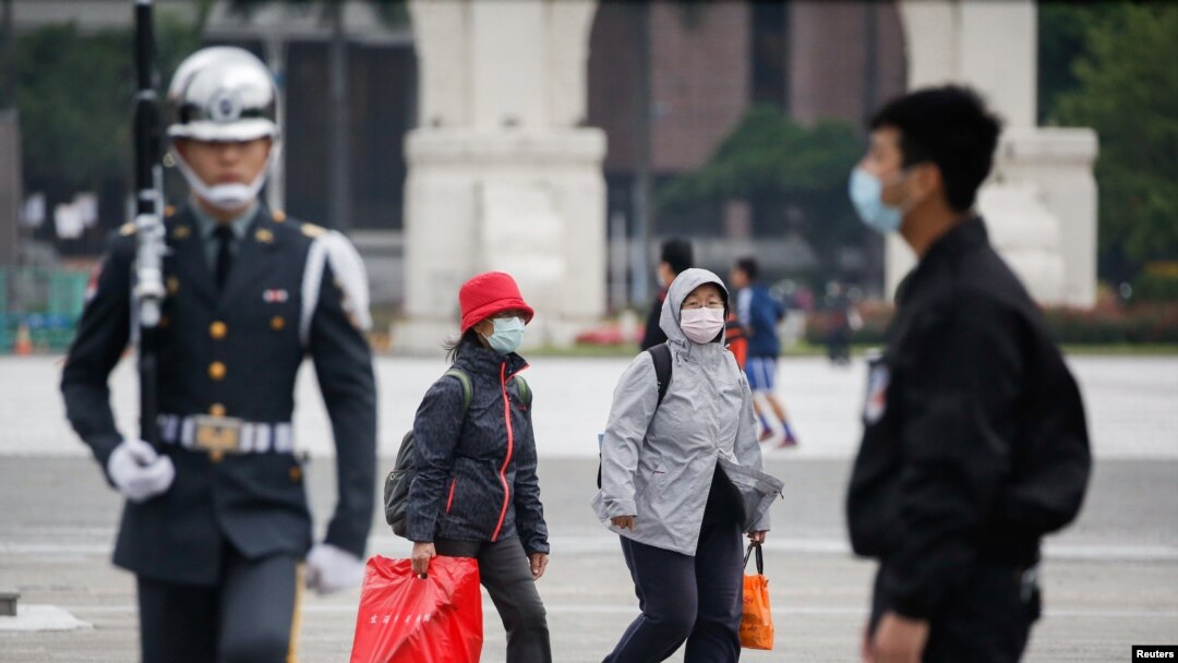 戴着口罩的游人在台北中正纪念堂看卫兵升旗仪式。（2020年3月11日）