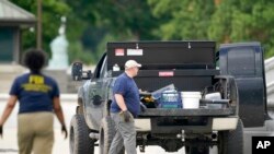 Authorities investigate a pickup truck parked on the sidewalk in front of the Library of Congress' Thomas Jefferson Building, in Washington, Aug. 19, 2021. A man who claimed to have a bomb surrendered to law enforcement after an hourslong standoff.