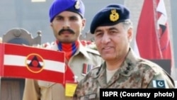 Former Lieutenant General Faiz Hamid, right, shown here in an undated photo provided by Pakistan's Inter-Services Public Relations, was charged with several criminal offenses, the Pakistani military announced on Dec. 10, 2024.