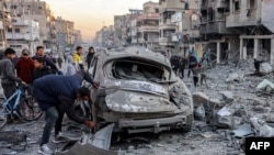 Raia akichunguza gari lililoharibika kufuatia mapigano yanayoendelea katika mitaa ya Gaza City. January 14, 2025. 