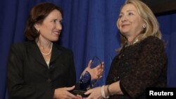 Menlu AS Hillary Clinton (kanan) menyerahkan Penghargaan "Common Ground" untuk menghormati almarhum Christopher Stevens yang terbunuh di Libya kepada saudara perempuannya, Anne Stevens di Washington DC (8/11).