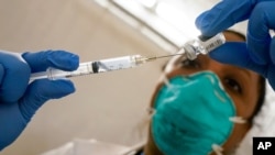 La doctora Yomaris Peña, del centro de salud Somos Cummunity Care, extrae los últimos residuos de un frasco de la vacuna de Pfizer/BioNTech en enero pasado.