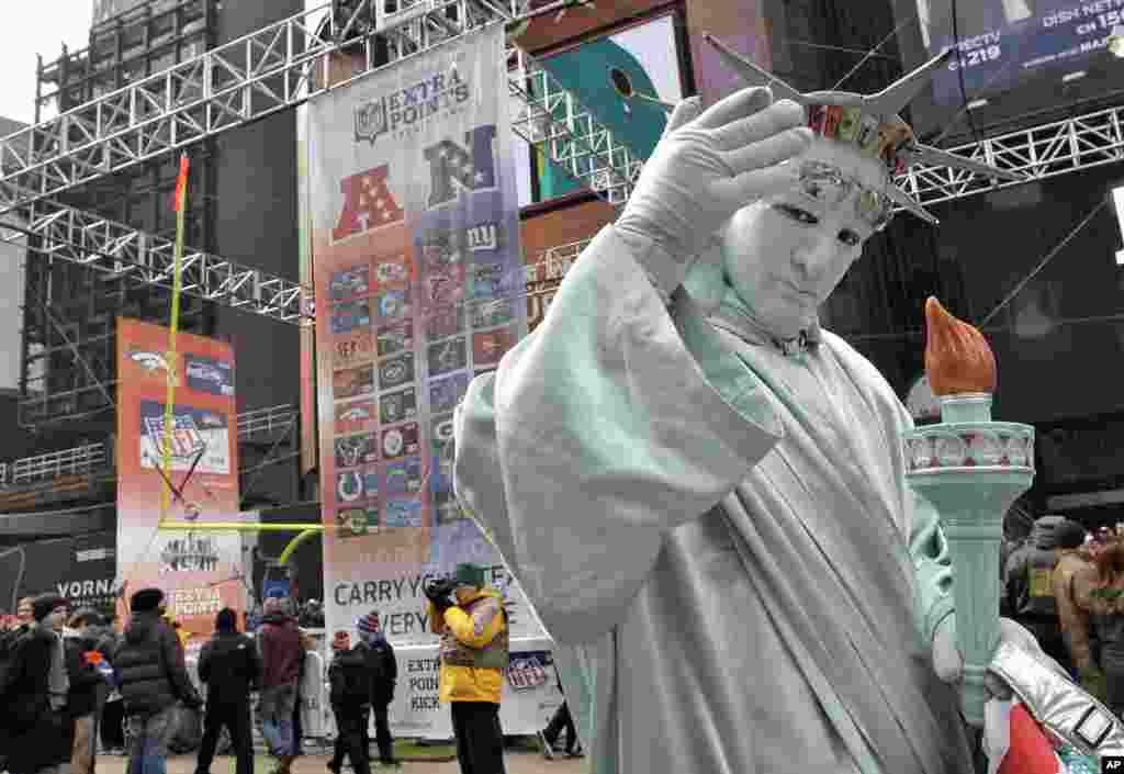 Seorang pria berpakaian seperti Patung Liberty di Super Bowl Boulevard (31/1) di New York. (AP/Chris O'Meara)