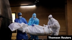 La cifra mundial de muertes por coronavirus en todo el mundo supera los 900.000, mientras se suspenden ensayos de vacuna contra la COVID-19.