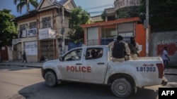Policías armados recorren las calles de Puerto Príncipe, la capital haitiana, tras el llamado a una huelga general lanzada por varias asociaciones profesionales y empresas para denunciar la inseguridad en el país, el 18 de octubre. 2021.