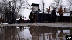 La gente camina junto a la puerta ''Arbeit Macht Frei" (El trabajo te libera) en el antiguo campo de concentración y exterminio alemán nazi Auschwitz-Birkenau en Oswiecim, Polonia, el jueves 26 de enero de 2023.