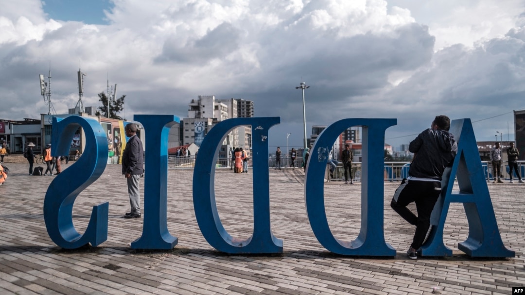 FILE - A man leans on a sign, in Addis Ababa, Sept. 26, 2022. Members of the tourism sector hope the November peace deal between the Ethiopian federal government and the Tigray People’s Liberation Front will help boost tourism. 