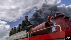 Los bomberos se desplazan en un camión dentro de la base de supertanqueros de Matanzas para sofocar un incendio el domingo 7 de agosto de 2022. (Foto AP/Ramón Espinosa)