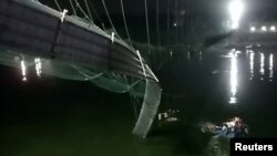 La foto muestra un sector dañado del puente de suspensión después de desplomarse en el poblado de Morbi, India, el 30 de noviembre de 2022.