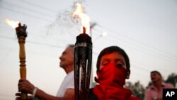 ARCHIVO - Personas sostienen antorchas durante una marcha para exigir justicia por el asesinato de la ambientalista y líder indígena Berta Cáceres, casi un mes después de su muerte, en Tegucigalpa, Honduras, en abril de 2016.