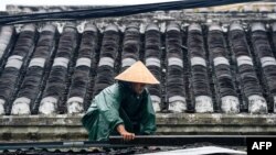 A resident consolidates the roof of house before typhoon Noru slams Vietnam, in Hoi An, Quang Nam province, on September 27, 2022. 