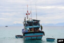 This photo taken on August 20, 2022 shows fishermen onboard their vessel near Ly Son island in Vietnam's Quang Ngai province. - Since 2014, 98 Vietnamese boats have been destroyed by Chinese vessels, according to figures from the local fishing association on Ly Son, home to hundreds of fishermen and their families whose livelihoods depend on trips out to sea.