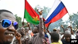 FILE - Supporters of Burkina Faso's new junta leader, Ibrahim Traore, hold national flags of Burkina Faso and Russia during a demonstration near the national radio and television headquarters in Ouagadougou, Oct. 6, 2022. Traore became president after the West African country's second coup in less than nine months.