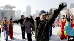 Warga Korea Utara meluapkan kegembiraan mereka atas keberhasilan peluncuran roket mereka dengan menari di depan Pyongyang Grand Theater di Pyongyang, Korea Utara (12/12). Para analis memperkirakan hanya sedikit hal yang dapat dilakukan masyarakat Internasional untuk mengontol perilaku Korea Utara pasca keberhasilan peluncuran ini.