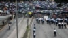 Seorang polisi menjaga jalan saat para pengunjuk rasa menggelar demonstrasi menentang RUU Ekstradisi yang kontroversial di luar kantor pemerintah di Hong Kong, 12 Juni 2019. (Foto: AFP)
